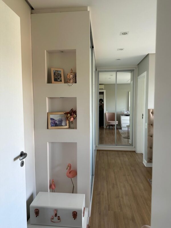 ARMÁRIO EM “L” — PORTAS DE CORRER — 3 DELAS DE VIDRO SERIGRAFADO + 2 DELAS EM ESPELHO — PARTE INTERNA COMPOSTA POR GAVETAS, PRATELEIRAS, ARARAS, GAVETAS COM DIVISÓRIAS PARA BIJUS, CALCEIROS, ÁREA PARA ROUPAS LONGAS — MDF COM LACA BRANCA — NICHOS LATERAIS COM ILUMINAÇÃO - Imagem 9